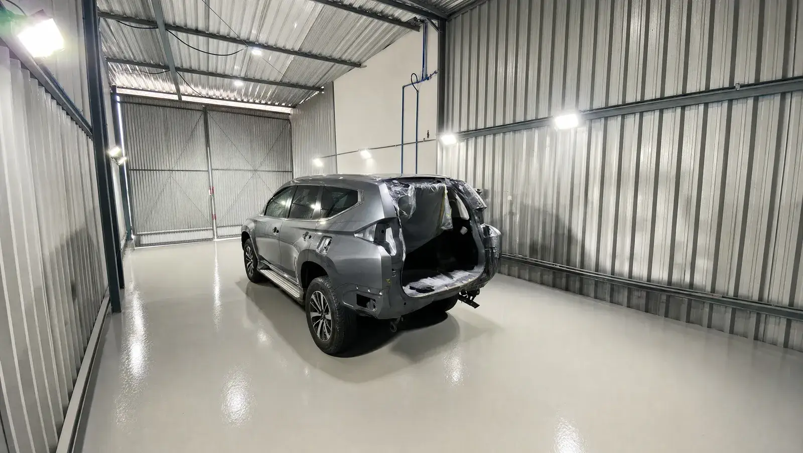 Veículo mascarado e preparado para pintura no setor de funilaria da Cidade Automotiva