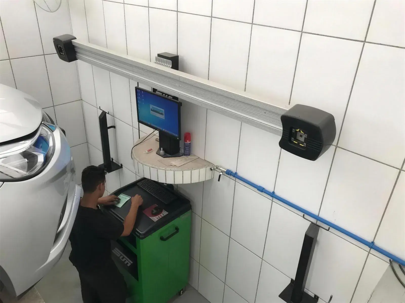 Técnico da Cidade Automotiva operando o alinhamento computadorizado